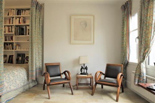 a bedroom with two chairs and a bed at La Belle Aventure in Pont-lʼÉvêque