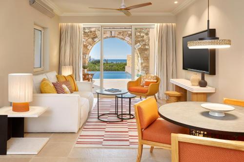 a living room with a couch and a table at The Westin Resort, Costa Navarino in Romanu