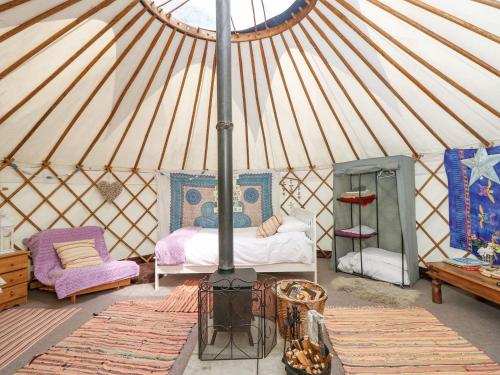 Una habitación con cama y estufa en una yurta en Stardust, en Ventnor