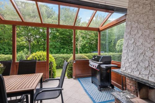 porche cubierto con mesa y fogones en Das Familien Nest by ALA Living - LEGOLAND in 8min! - privater Garten & Grill, en Leipheim