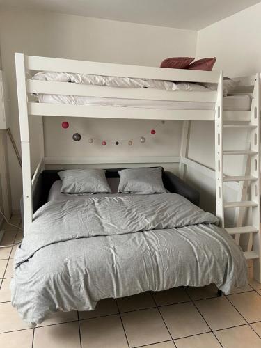 une chambre avec un lit superposé avec une échelle dans l'établissement Studio près gare Amiens et centre, à Amiens