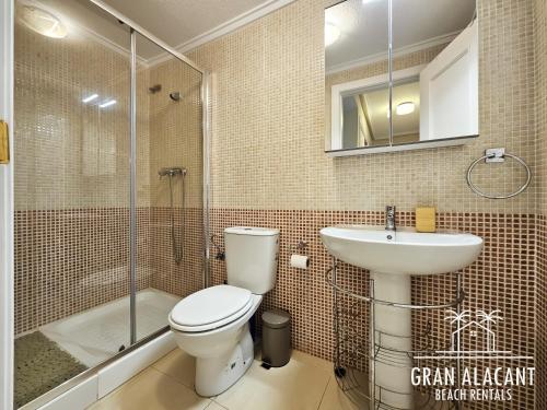 Un baño con inodoro, lavabo y ducha. en Chalet Adosado en Gran Alacant - Monte y Mar, en Santa Pola