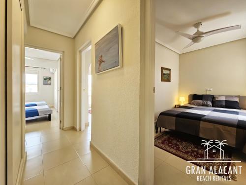 1 dormitorio con 1 cama y pasillo en Chalet Adosado en Gran Alacant - Monte y Mar, en Santa Pola