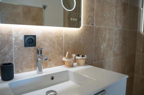 une salle de bain avec un lavabo et un miroir dans l'établissement Soléna - Appartement Vue Mer Climatisé 2 Chambres, à Cavalaire-sur-Mer