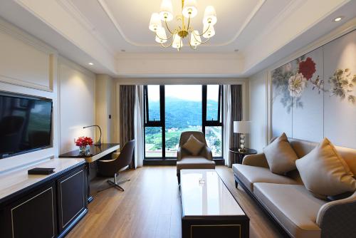 a living room with a couch and a tv at Ramada Plaza by Wyndham Wenzhou in Wenzhou