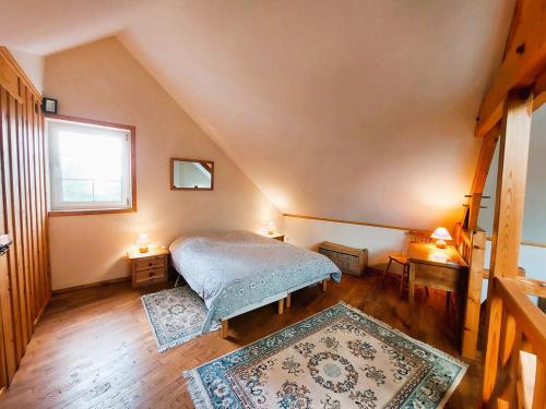 - une chambre avec un lit et deux tapis dans l'établissement Gîte et gîte équestre dans ancienne laiterie rénovée, à Saint-Sauveur-le-Vicomte