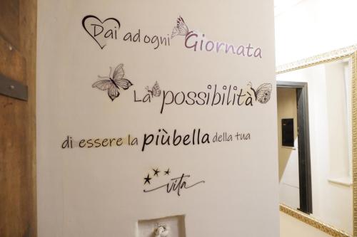 a bathroom with a mirror and words on the wall at YNH Mono SanCarlo Egyptian Museum Piazza San Carlo in Turin