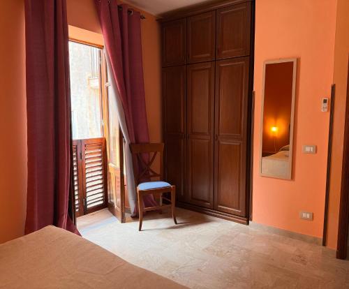 a bedroom with a bed and a window and a chair at MiraMare Residence Cefalú in Cefalù