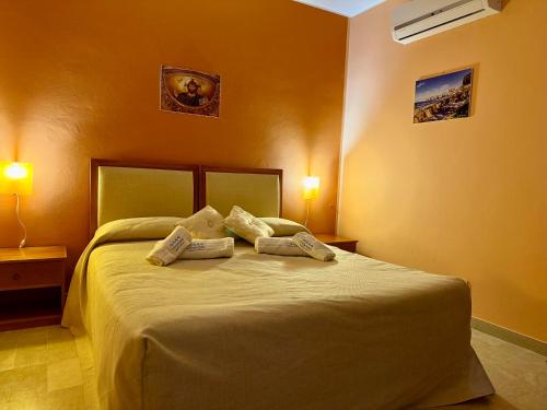 a bedroom with a bed with two pillows on it at MiraMare Residence Cefalú in Cefalù