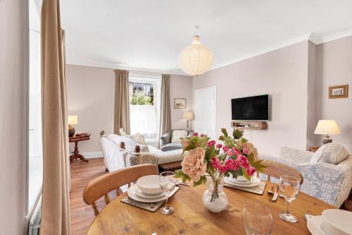 a living room with a table with flowers on it at Learchild House - North East Escapes in Alnwick