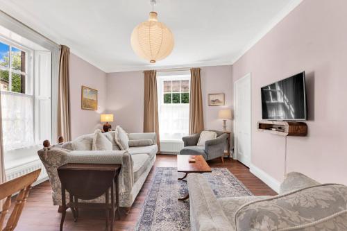 a living room with a couch and a tv at Learchild House - North East Escapes in Alnwick