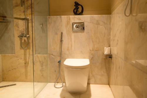 a bathroom with a toilet and a glass shower at La Zona Continental Hotel in Dubai