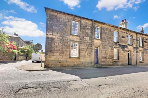 an old brick building on the side of a street at Learchild House - North East Escapes in Alnwick