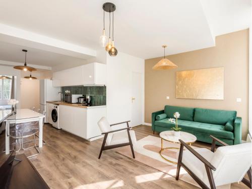 un salon avec un canapé vert et une table dans l'établissement Merveil - Family Suite - Marais - Fbg St Antoine, à Paris