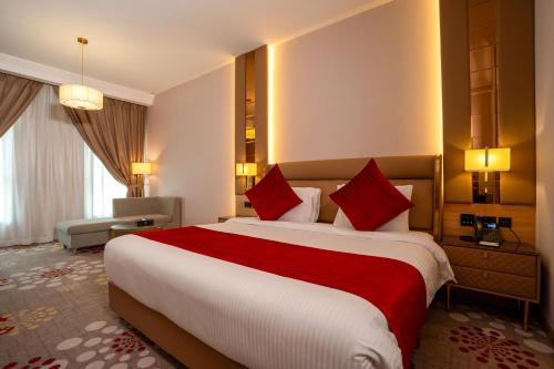 a hotel room with a large bed with red pillows at La Zona Continental Hotel in Dubai