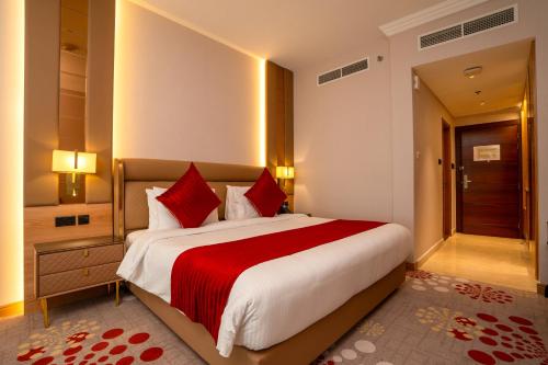 a bedroom with a large bed with a red blanket at La Zona Continental Hotel in Dubai