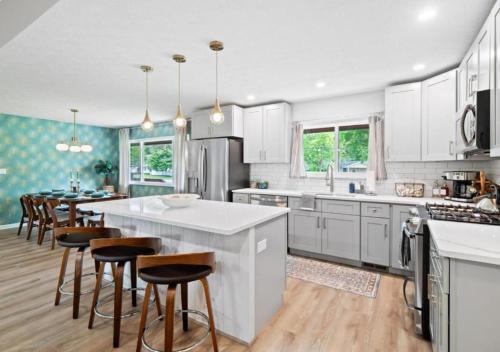 a kitchen with white cabinets and a large island with bar stools at Spacious and Luxury Designed Ranch with Game Room in Strongsville