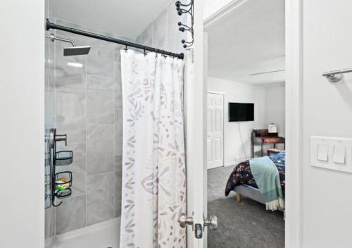a bathroom with a shower and a bedroom with a bed at Spacious and Luxury Designed Ranch with Game Room in Strongsville
