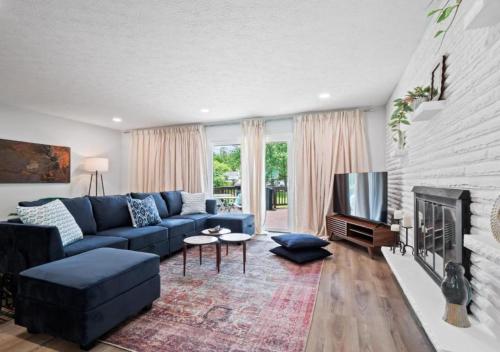 a living room with a blue couch and a tv at Spacious and Luxury Designed Ranch with Game Room in Strongsville