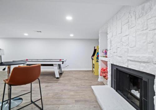 a living room with a fireplace and a ping pong table at Spacious and Luxury Designed Ranch with Game Room in Strongsville