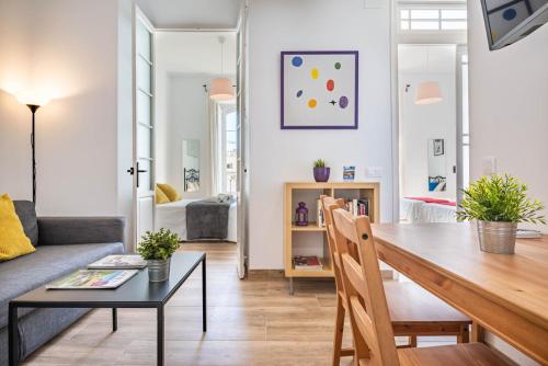 een woonkamer met een tafel en een bank bij Apartamentos Alcazaba in Málaga