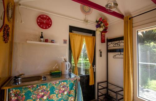 a kitchen with a sink and a clock on the wall at Bed & Brood Morgenrood in Bruchterveld