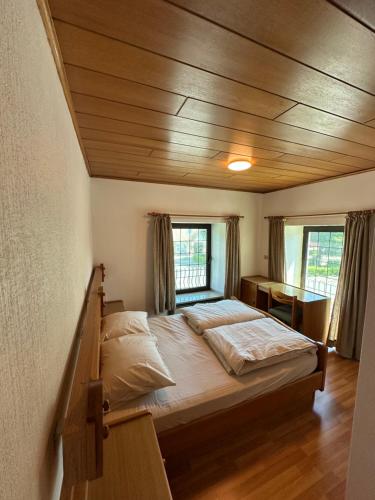 a bedroom with a large bed with a wooden ceiling at Hotel Restaurant Ming Court in Hürtgenwald
