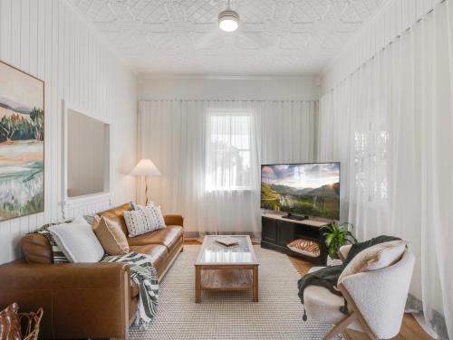 a living room with a couch and a tv at Edwin Cottage in Toowoomba