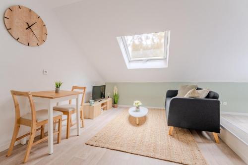 - un salon avec une table et une horloge murale dans l'établissement Bright Studio for 2 : Lille City-center, à Lille