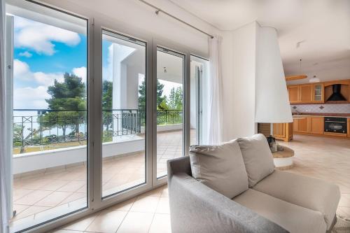 a living room with sliding glass doors at Vista Mare Blu House in Agioi Theodoroi
