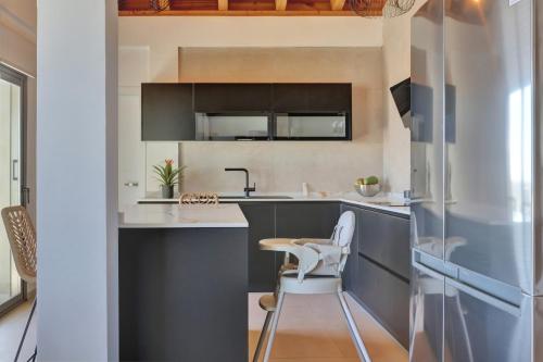 una cucina con armadi grigi e piano di lavoro bianco di Prestige luxe villa pacific ocean solar energy a Caleta De Fuste