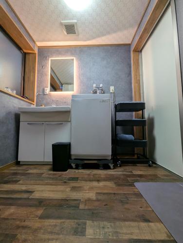 a bathroom with a sink and a chair in a room at 蔵サウナのある貸切古民家宿 ojirotomarlo in Tsuiyama
