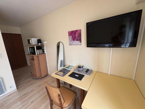 Cette chambre dispose d'un bureau et d'une télévision murale. dans l'établissement StudiosMichel apt 16 balcon thermes 400m à pied, à Cazaubon