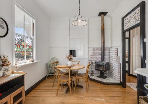 a living room with a table and a fireplace at Edwin Cottage in Toowoomba