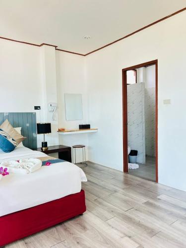 a bedroom with a bed and a desk and a mirror at Three Trees Samui Resort - Sarocha Villa in Lamai