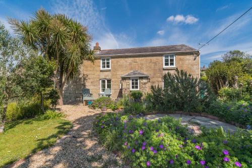 una casa de piedra con un jardín delante en Matchells, en Freshwater