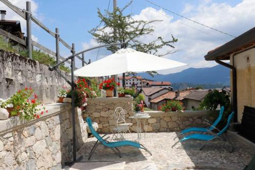 a table and two chairs with an umbrella at Il nido del pettirosso in Enego