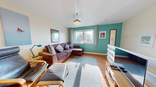a living room with a couch and a table at Bryntin in Penzance