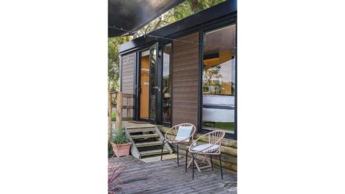 a patio with chairs and a table on a house at The Junction by Tiny Away in Yarra Junction