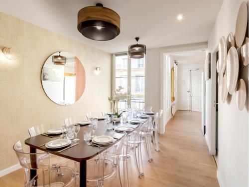 une longue salle à manger avec une longue table et des chaises dans l'établissement Merveil - Family Suite - Louvre - Sainte Anne, à Paris