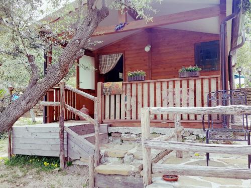 a log cabin with a porch and a tree at Dimora Acqua del Fico in Castellabate