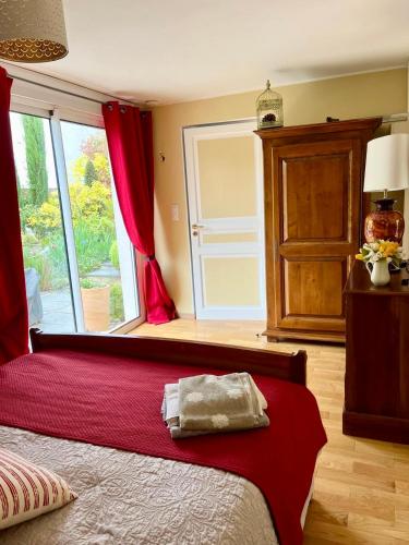 a bedroom with a large bed with a large window at Gîte chez Madeleine in Louhans