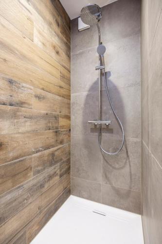 a bathroom with a shower with wooden walls at Harderwold Villa Resort XL in Zeewolde