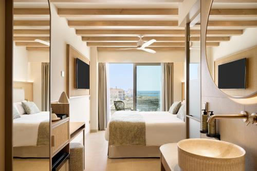 a hotel room with two beds and a bathroom at Iberostar Selection Es Trenc -New Opening- in Colonia Sant Jordi