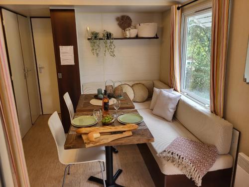 - une table à manger dans une petite maison avec une fenêtre dans l'établissement Mobilehome Leï Suves Côte d'Azur, à Roquebrune-sur Argens