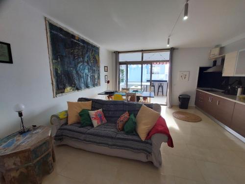 Una sala de estar con un sofá con almohadas. en MyHomebytheOcean, en Puerto Naos