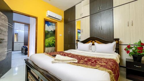 a bedroom with a large bed with yellow walls at S V IDEAL HOMESTAY -2BHK SERVICE APARTMENTS-AC Bedrooms, Premium Amities, 2KM to Tiruchanoor Padmavathi Temple , 6KM to Alipiri, 24 HOURS Service BOYS Available in Tirupati
