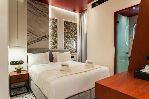 a bedroom with a white bed with towels on it at Athens Retro in Athens
