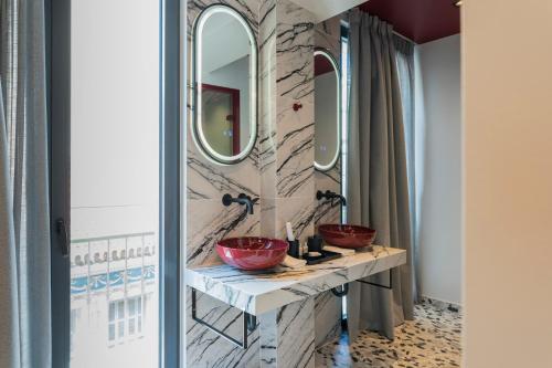 a bathroom with two sinks and two mirrors at Athens Retro in Athens