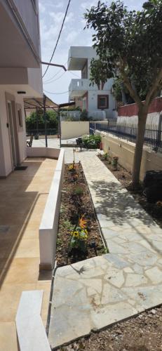 a bench in a garden next to a building at GLIPTIS Apartments in Karfas